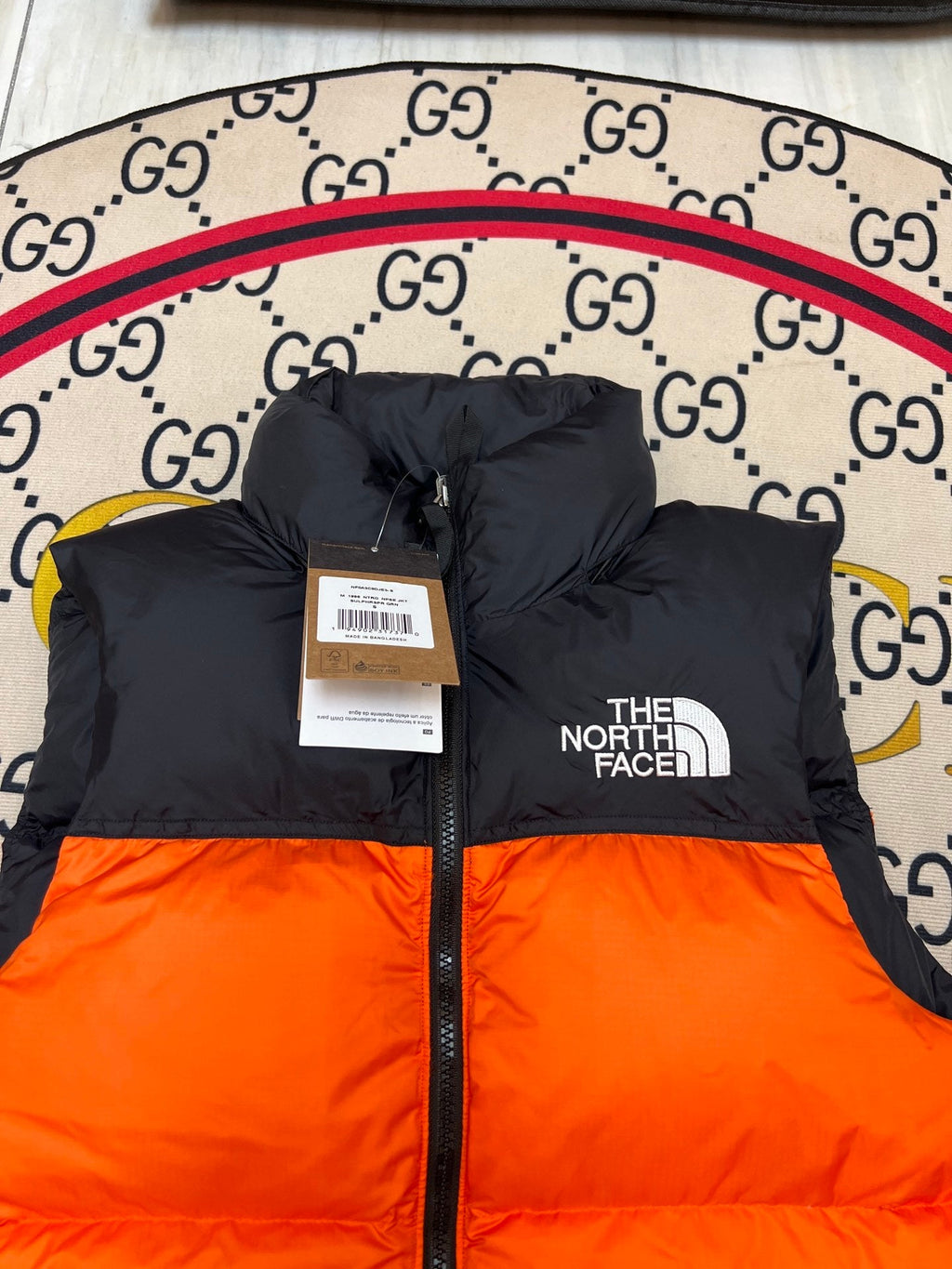 The North Face Puffer Vest in Orange and Black with Stand Collar